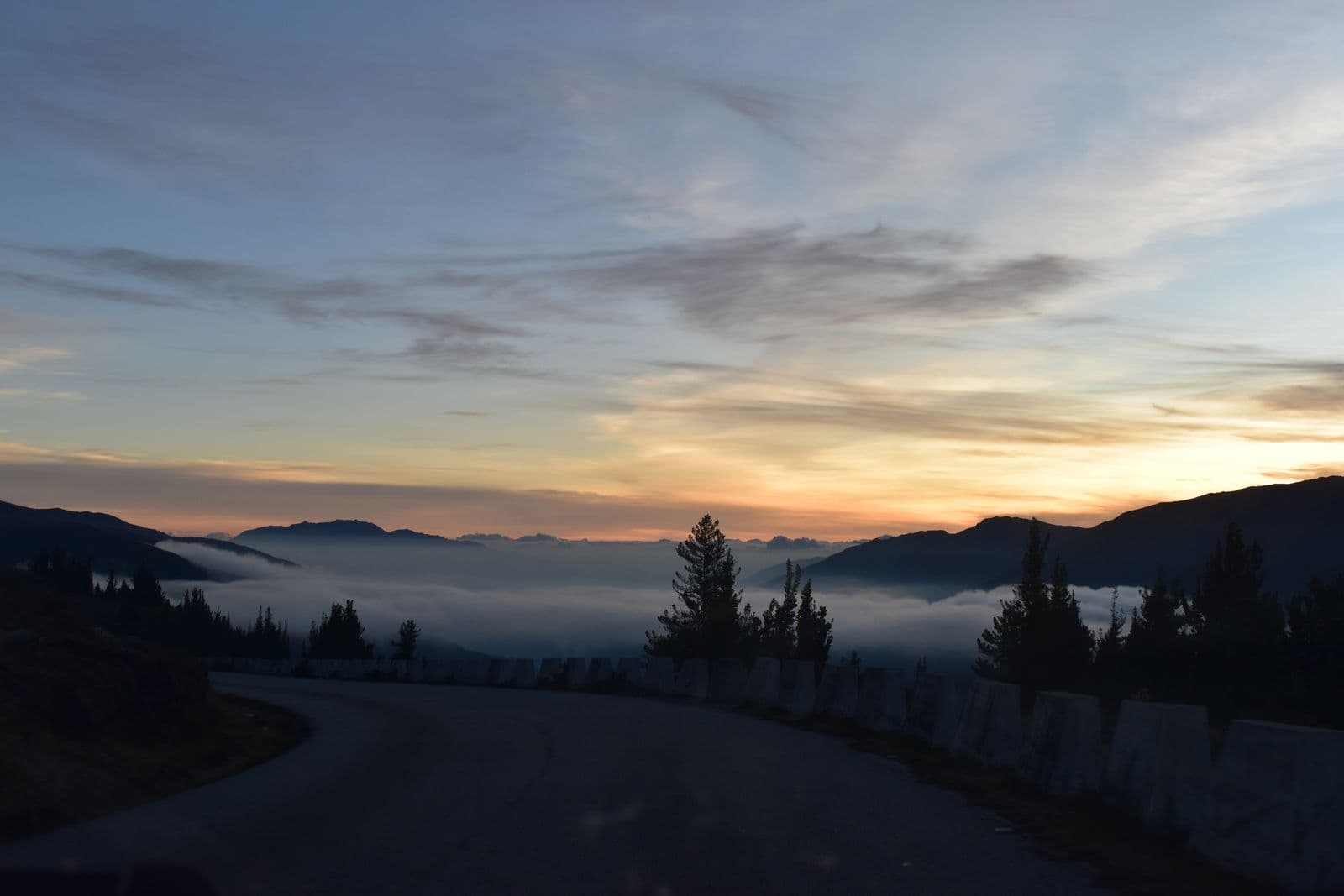 A winding path leading toward a misty mountain sunrise