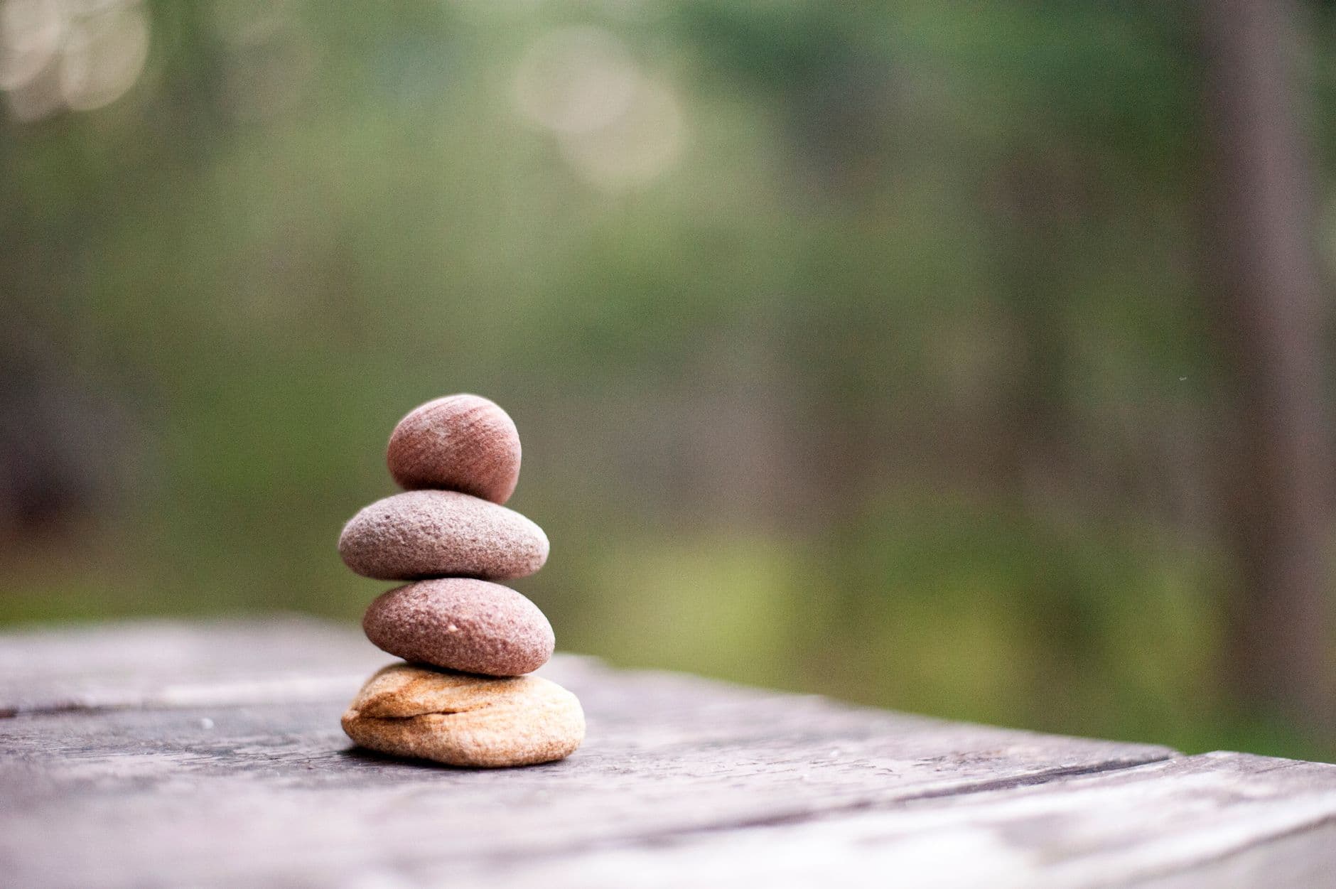 A stack of smooth balanced stones against a soft green background